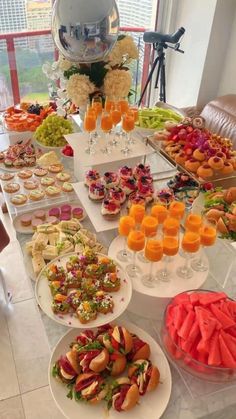 a table filled with lots of food and drinks on top of white plates next to each other