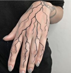 a woman's hand with tattoos on it and lightning drawn on the palm area