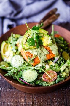 a wooden bowl filled with salad and dressing