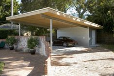 a car is parked in front of a house with a carport attached to it