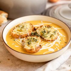 a bowl of soup with bread on the side