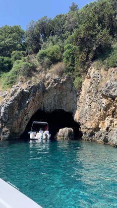 a boat is in the water near a cave