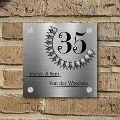 a metal plaque with the number 35 on it is mounted to a brick wall,