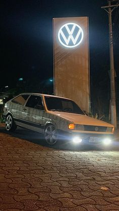 a car parked in front of a volkswagen sign at night