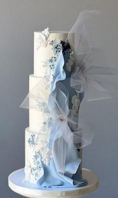 a three tiered wedding cake with blue and white decorations