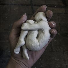 a person holding a small white object in their left hand and it's shaped like a human heart