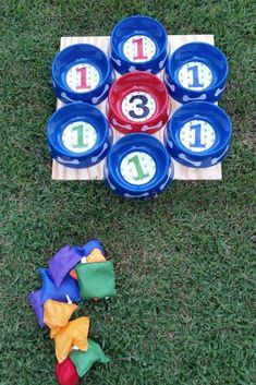 a set of frisbees with numbers on them sitting in the grass next to a game board