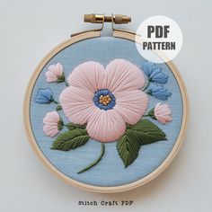 an embroidery pattern with pink flowers and green leaves on a light blue background is shown