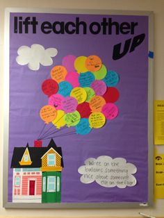 a bulletin board with a house and bunch of balloons attached to the front of it that says lift each other up