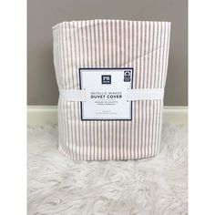 the duvet cover is striped in brown and white, with a blue label on it