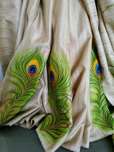 the fabric has peacock feathers painted on it