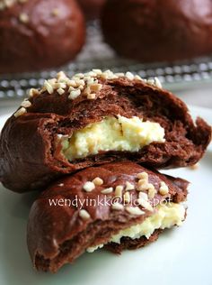 two chocolate cookies with white frosting and sprinkles are on a plate