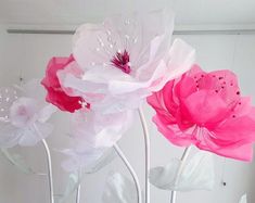 three pink and white flowers are in a vase