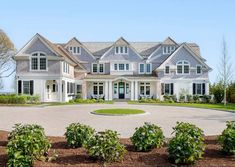 a large white house with lots of windows on it's front porch and driveway