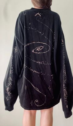 the back of a woman's black shirt with an image of planets and stars on it