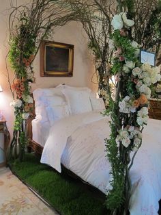 a bedroom decorated with white flowers and greenery