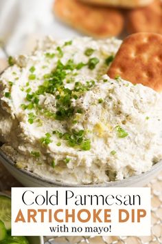 a close up of a bowl of artichoke dip with crackers in the background