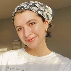 a woman wearing a white t - shirt and a bandana on her head