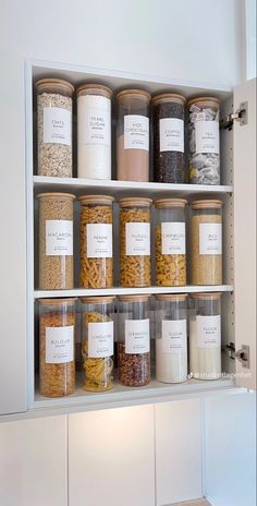 the shelves are filled with many different types of food in glass containers and labeled labels