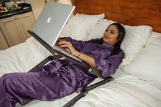 a woman laying in bed using a laptop computer