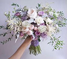 a person holding a bouquet of flowers in their hand