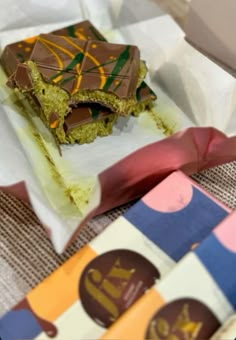 a piece of cake sitting on top of a white paper wrapper next to a box