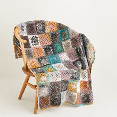 a multicolored blanket sitting on top of a wooden chair