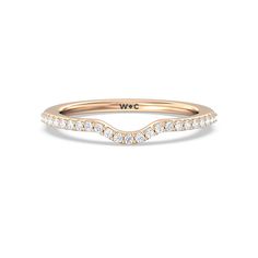 a rose gold wedding band with white diamonds on the side and a curved design in the middle