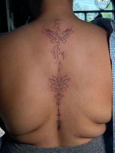 the back of a woman's upper body with tattoos on her left and right side