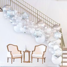 balloons and chairs are on the floor in front of a staircase