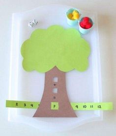 a paper plate with a tree cut out and measuring tape on it, next to some fruit