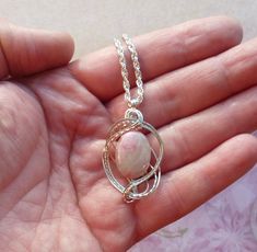 This pink peruvian opal necklace pendant is wire wrapped in silver and completely handmade by me. This is my own original design and is entirely unique. If you are looking for something eye catching and one of a kind I can guarantee that you will not see similar piece anywhere unless it's also one of mine! Please note that the stone pictured is a sample only, yours will be the same color, size and shape but there will be some natural variations. About the Stone: The stones I use in this design a Silver Opal Wire Wrapped Necklace, Pink Opal Jewelry Gift, Handmade Pink Opal Round Jewelry, Unique Pink Opal Jewelry For Gifts, Handmade Pink Opal Pendant Necklace, Handmade Round Pink Opal Jewelry, Handmade Pink Opal Spiritual Jewelry, Handmade Pink Opal Jewelry Gift, Opal Necklace Pendant