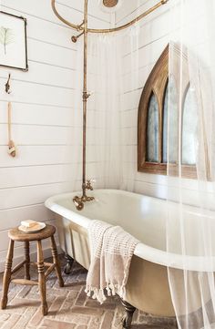 an old fashioned bathtub in a bathroom with white walls and wood trimmings