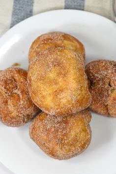 some sugared doughnuts are on a white plate