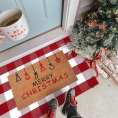 someone standing in front of a door with their feet on the mat that says merry christmas