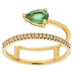 A stunning green emerald is balanced perfectly in the center of this ring, with the glossy band moving above and below. The jewelry has sparkling white diamonds along one side and the 18k yellow gold offers the ideal color contrast to such an eye-catching style. Details Green pear-cut Gin & Grace Natural emerald measures 5 mm wide x 7 mm long Gemstone weight: 0.66 carats 23 round-cut white diamonds each measuring 1mm Prong-set stones Diamond weight: 0.12 carat Color is G-H, clarity is I1-I2 Poli Fine Jewelry Green Emerald Ring With Single Cut Diamonds, Luxury Green Rings With Single Cut Diamonds, Luxury Green Emerald Ring With Single Cut Diamonds, Luxury Green Diamond Open Ring, Elegant Green Open Band Jewelry, Luxury Rings With Diamond Accents For May Birthstone, Timeless Green Jewelry With Single Cut Diamonds, Green Diamond Open Ring, Timeless Green Rings With Diamond Accents