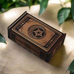 a wooden box sitting on top of a table next to green leafy plants and leaves