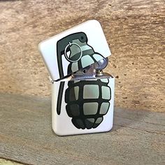 a lighter with an image of a bug painted on it's side, sitting on a wooden surface