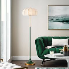 a living room with a green couch and lamp