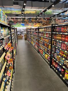 an aisle in a grocery store filled with lots of food and drinks on shelves next to each other