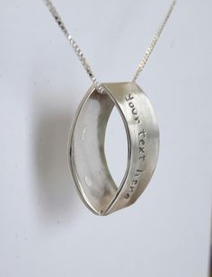 Name necklace silver ring, used as pendant or necklace, apparently flattened with custom text. A silver ring with a cut handmade and soldered, where viewed from the front has a ring appearance but seen laterally is a flattened jewel. The customer can request a custom text of 15 characters. Pay attention that the pendant has a price, the customer decides if you want the silver necklace with an additional price. Silver Round Pendant Necklace For Anniversary, Sterling Silver Custom Necklace For Anniversary, Unique Silver Jewelry For Anniversary Gift, Sterling Silver Hand Stamped Oval Pendant Jewelry, Silver Hand Stamped Oval Pendant Jewelry, Silver Hallmarked Custom Necklace For Personalized Gift, Silver Hallmarked Necklace For Personalized Gift, Silver Oval Pendant Jewelry Hand Stamped, Hand Stamped Sterling Silver Oval Pendant