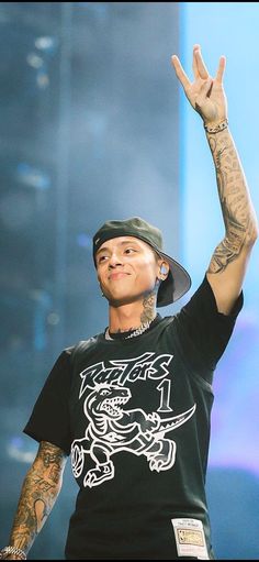 a man with tattoos on his arm and hand in the air