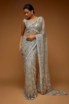 Light grey sheer saree embroidered all-over with transparent sequin, crystals, cutdana and beads. Comes with padded sleeveless blouse with crystal work.
Components: 2
Pattern: Embroidery
Type Of Work: Crystals, Cutdana, Sequin and Bead
Neckline: V neck
Sleeve Type: Sleeveless
Fabric: Tulle
Color: Grey
Other Details: 
Blouse with low V back
Sequin embroidery on the saree border
Occasion: Bride - Aza Fashions Grey Crystals, Pleated Saree, Neeta Lulla, Sequin Saree, Grey Saree, Modern Saree, Embroidered Saree, Sea Spray, Embellished Blouse