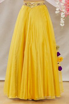 Yellow organza lehenga with embroidered waistband.  Comes with embroidered blouse and green soft net dupatta.
Component: 3
Pattern: Embroidered
Type Of Work: Mirror work
Neckline: V Neck
Sleeve Type: Sleeveless
Fabric: Blouse:Satin; Lehenga:Organza; Dupatta:Soft Net
Color: Yellow
Other Details: 
Side tassel tie-up lehenga
Occasion: Mehendi and Haldi - Aza Fashions Floor-length Organza Sets For Diwali, Luxury Organza Floor-length Sets For Diwali, Silk Long Skirt Set For Diwali, Navratri Floor-length Organza Dress, Silk Long Skirt Sharara For Navratri, Navratri Organza Floor-length Dress, Floor-length Organza Dress For Navratri, Organza Wedding Dress With Flared Skirt, Silk Anarkali Sharara With Long Skirt