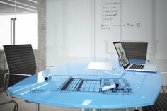 two laptops sitting on top of a blue table in front of a whiteboard