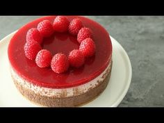 there is a cake with raspberries on it and red sauce in the middle