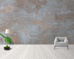 an empty room with a chair, lamp and potted plant on the floor in front of a concrete wall