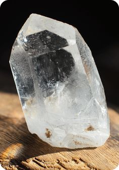 a clear rock sitting on top of a wooden table