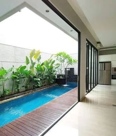 a small outdoor space with a wooden deck, a long and narrow pool, some potted plants and a waterfall is like a small heaven Garden Pool Design, Indoor Pool Design, Indoor Swimming Pool, Small Swimming Pools, Backyard Pool Landscaping