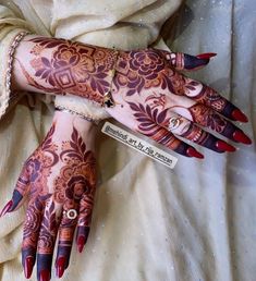 a woman's hands with henna tattoos on them